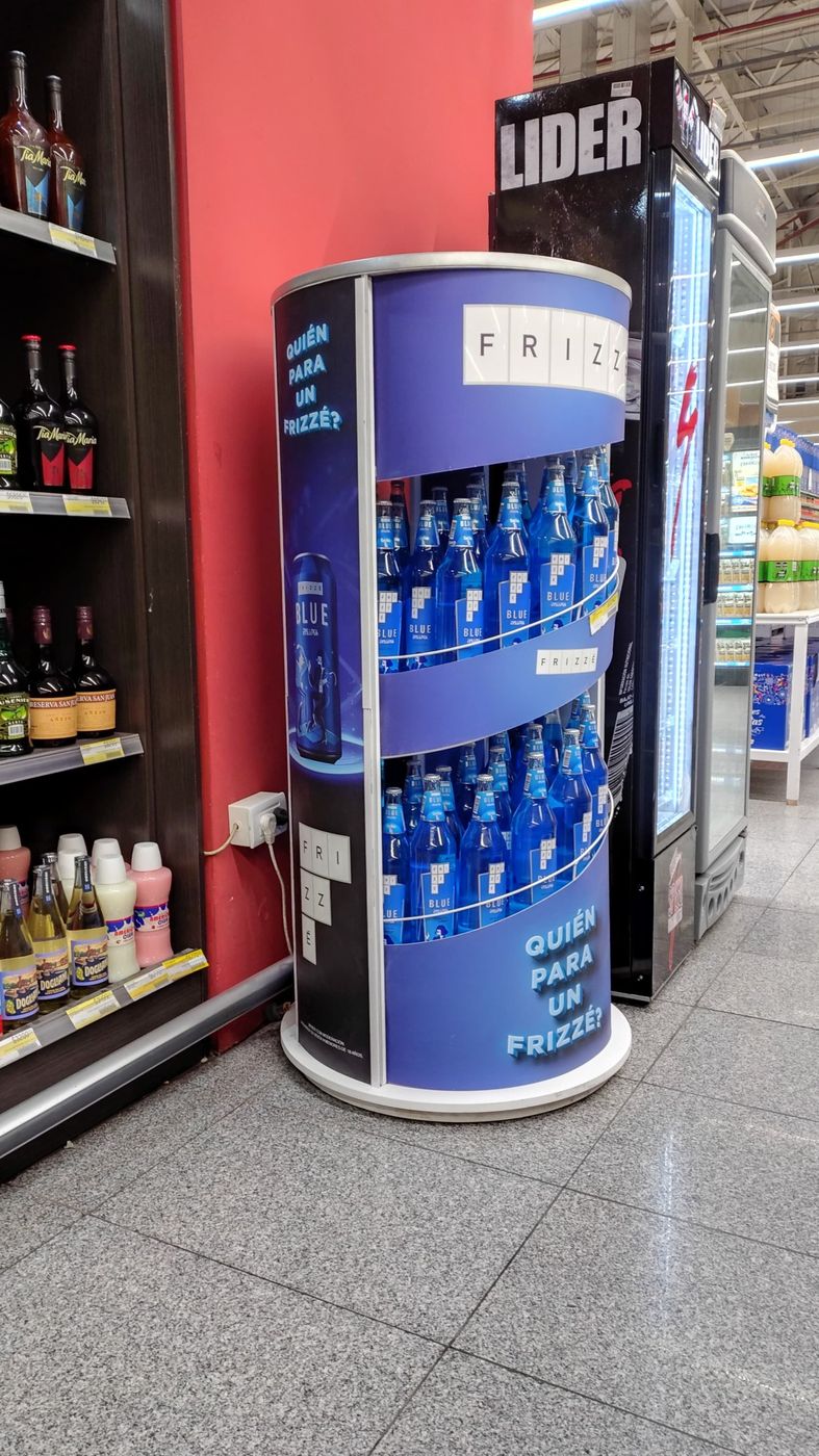 Exhibidor cilíndrico de Frizzé Blue junto a una heladera