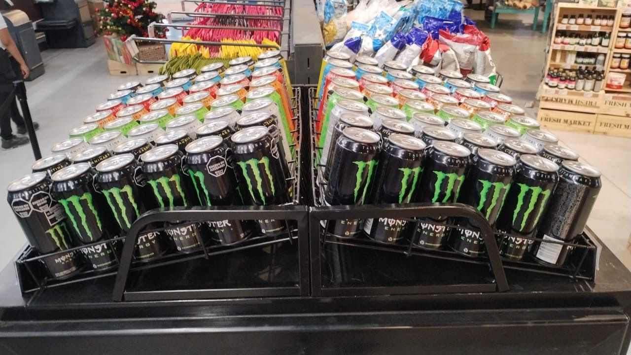 Bandejas metálicas de Monster Energy con latas sobre una isla